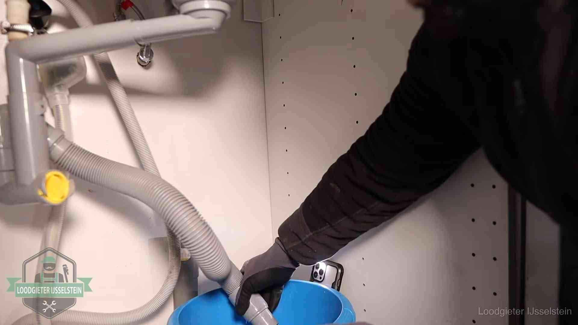 Afvoerslang loopt leeg in een emmer onder de gootsteen in IJsselstein, een klus die je zelf kunt doen