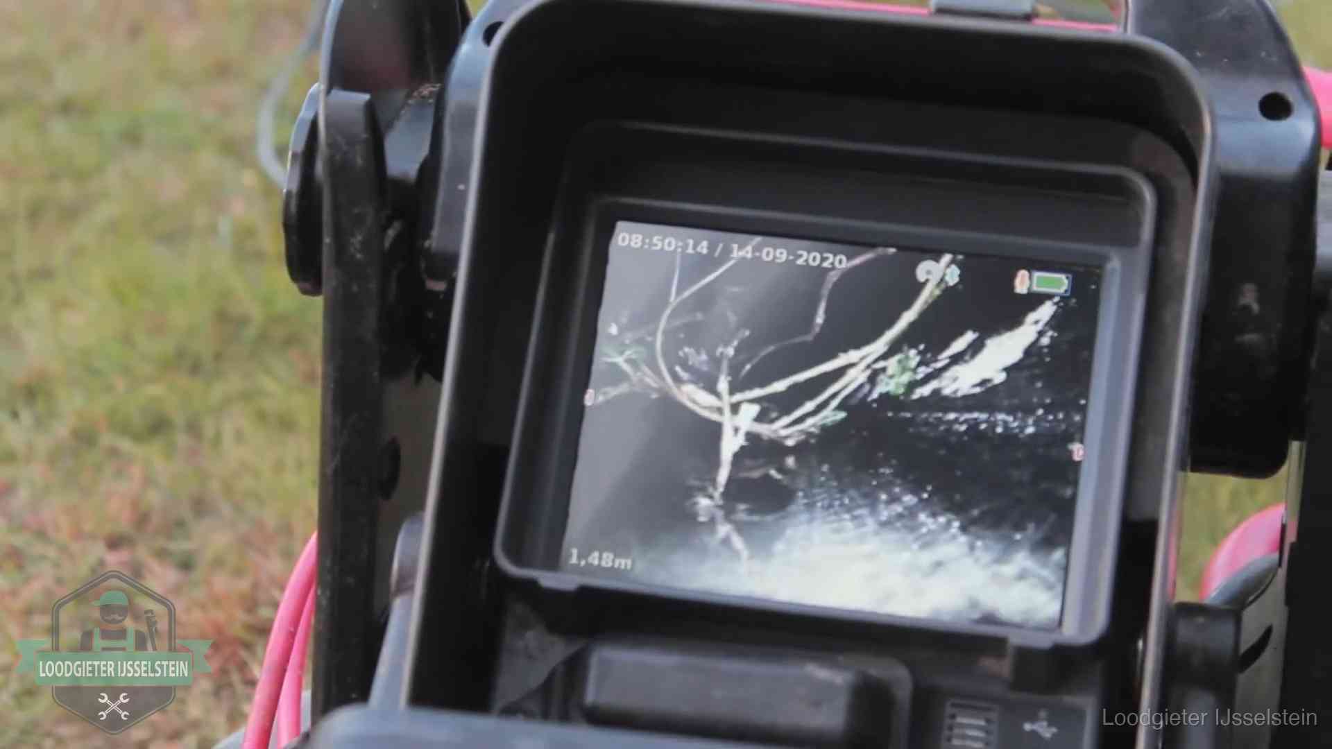 Monitor van een rioolcamera toont wortelingroei in de rioolbuis bij een woning in IJsselstein