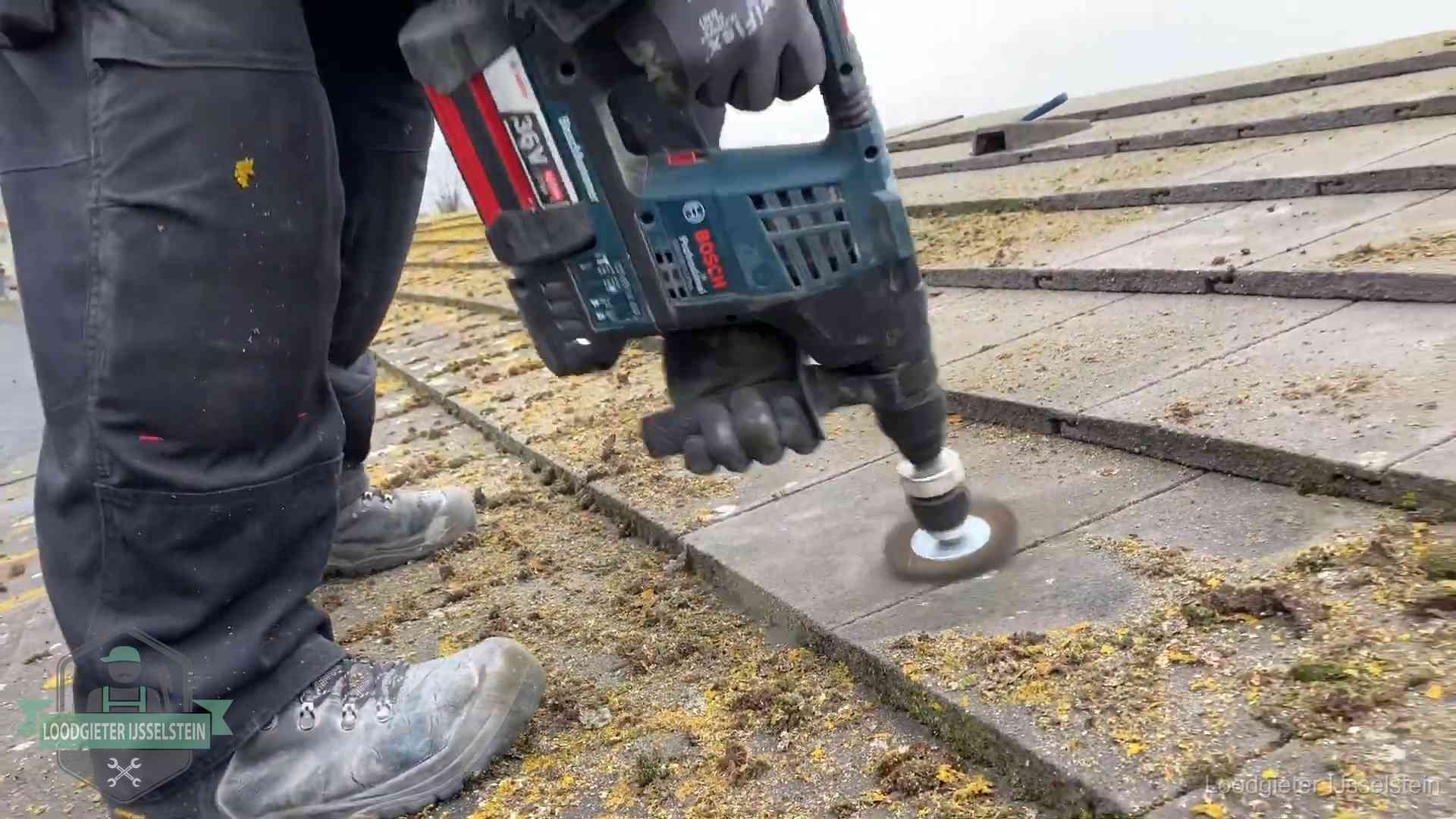 Betonnen dakpannen worden machinaal gereinigd tijdens dakonderhoud in IJsselstein
