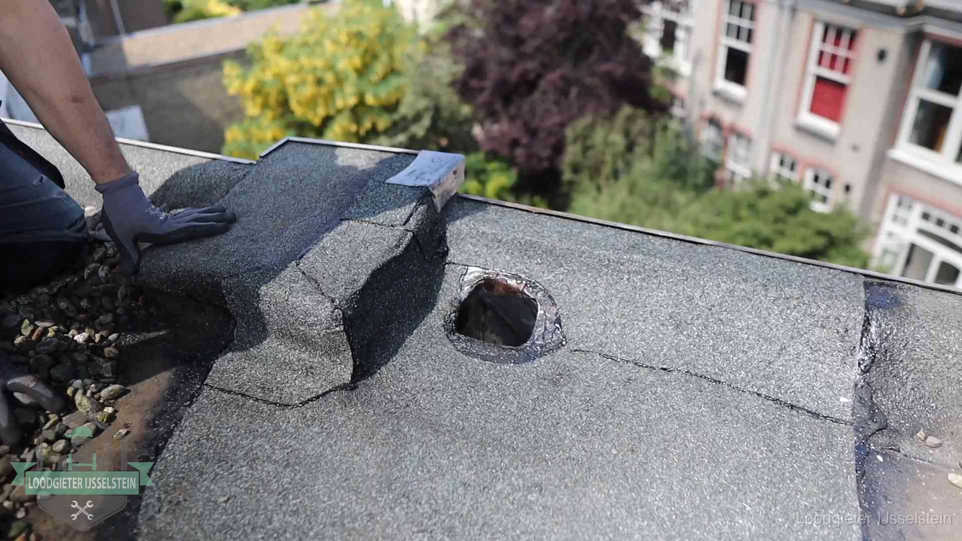 Loodgieter inspecteert een beschadigd bitumen plat dak tijdens een daklekkage-inspectie in IJsselstein