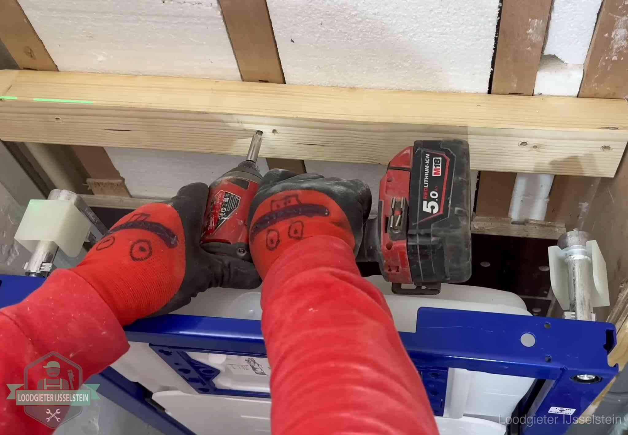 Monteur bevestigt een inbouwreservoir voor een hangend toilet in IJsselstein