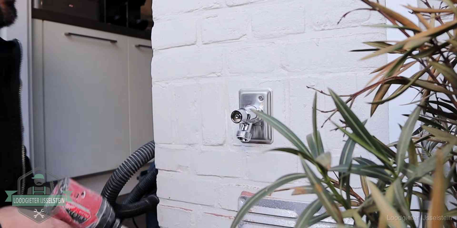 Chromen kraan op een muurplaat bij een woning in IJsselstein, dichtdraaien is stap een van de lektest