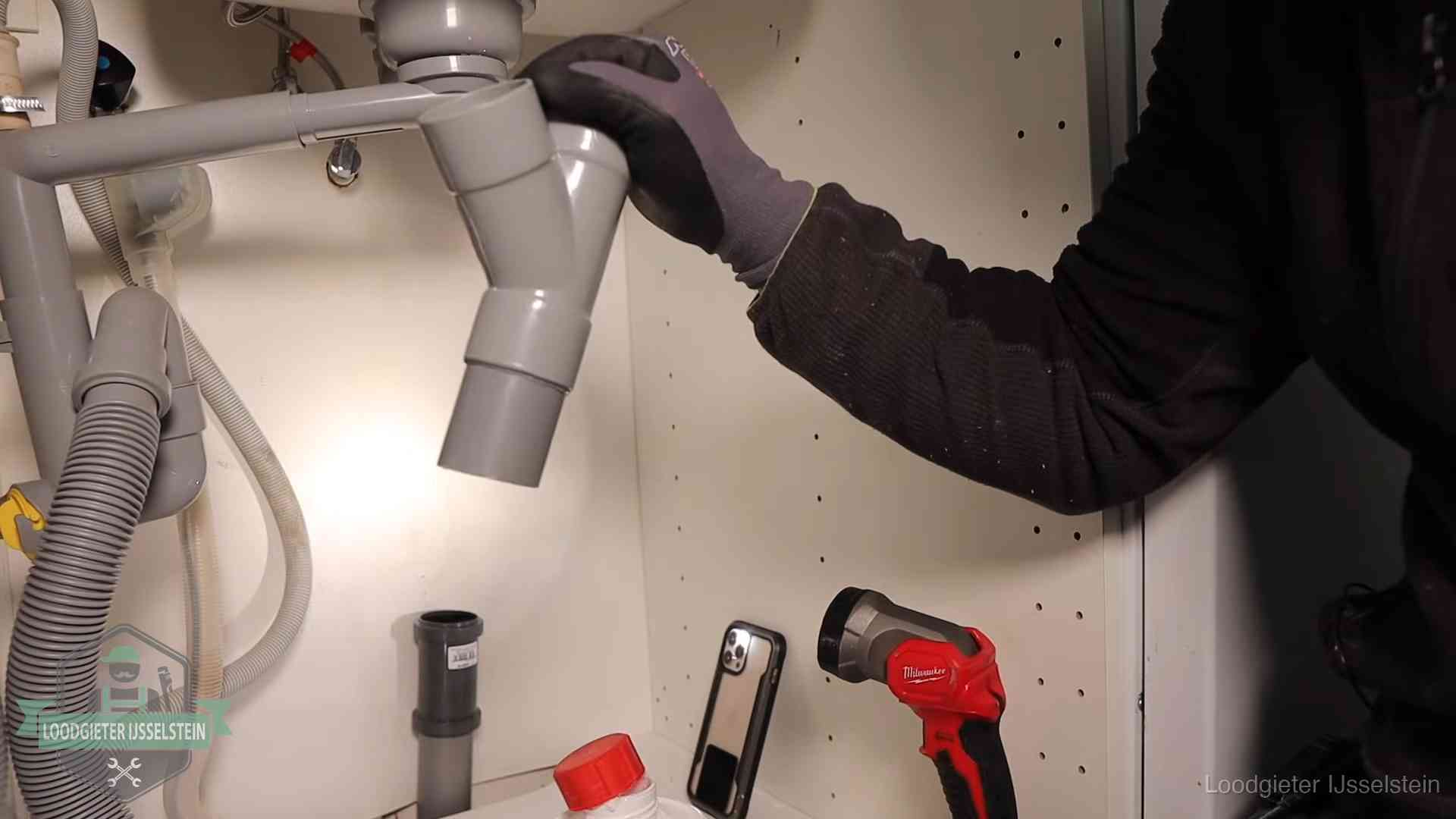 Loodgieter demonteert het sifon- en afvoerwerk onder een gootsteen in IJsselstein bij stankklachten