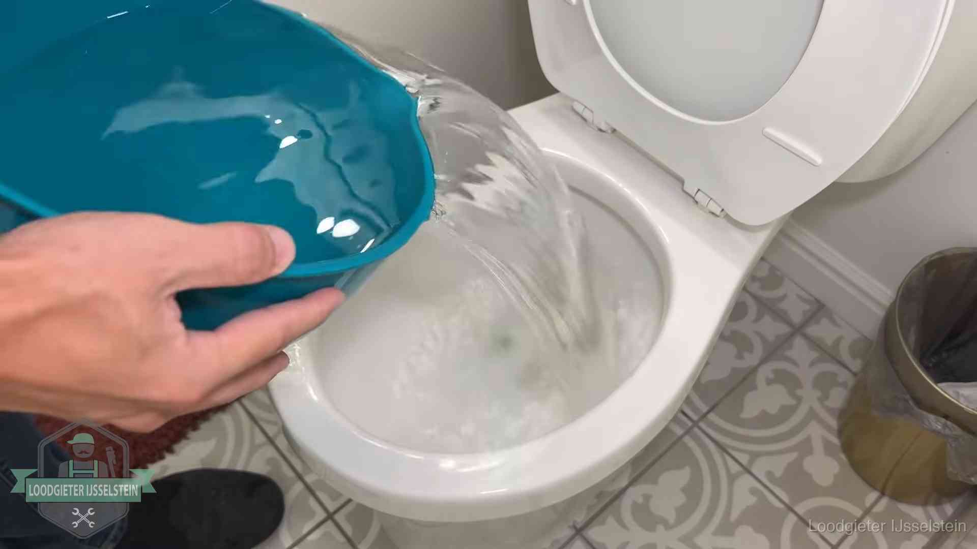 Warm water wordt voorzichtig in de wc-pot gegoten in IJsselstein
