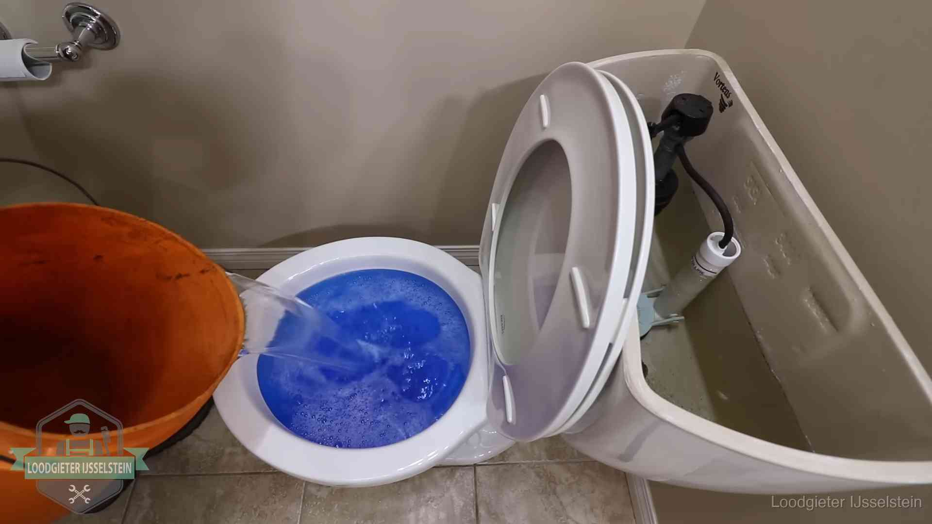 Water bij de wc-pot wordt met een emmer weggewerkt om schade te beperken in IJsselstein